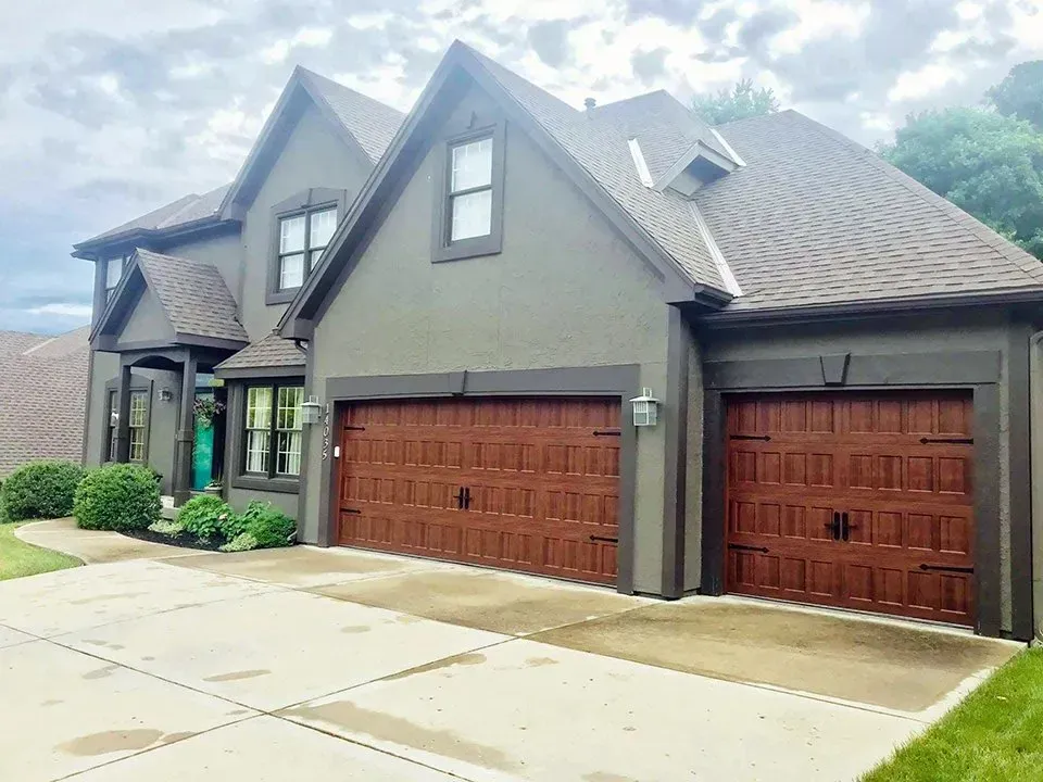 Wood-look garage doors on gray stucco home